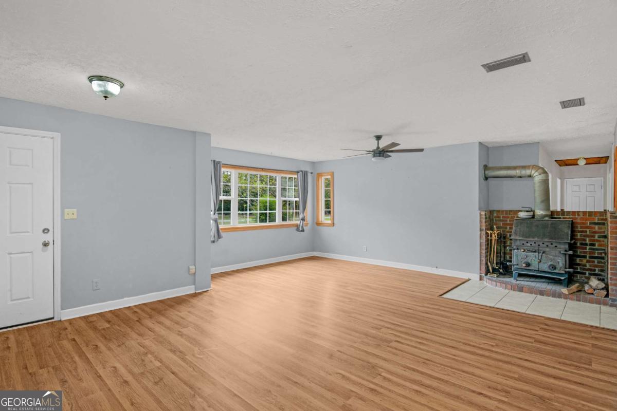 5837 Youmans Chapel Road Blackshear, GA 31516 - Photo 9 of 30 wooden floor in an empty room with a window