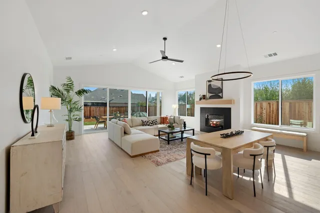 a living room with furniture a fireplace and a chandelier