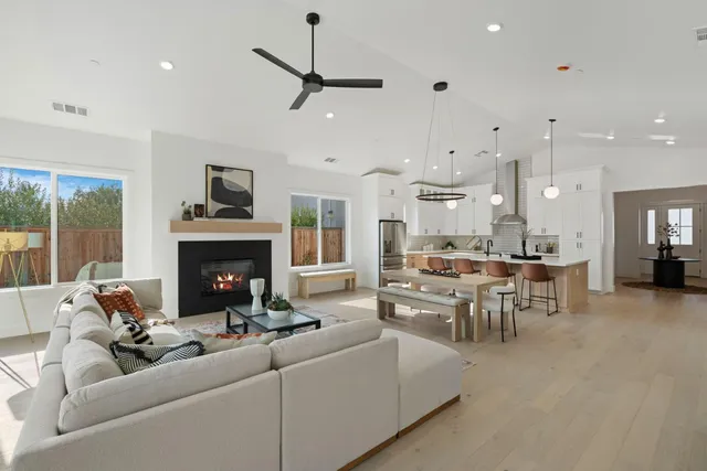 a living room with furniture a fireplace and kitchen view