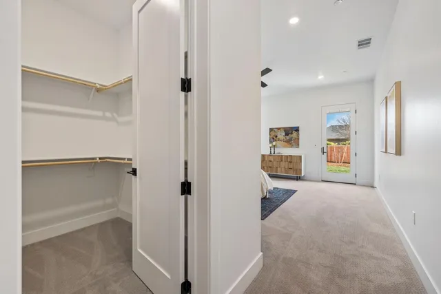 an empty room with ceiling fan and windows