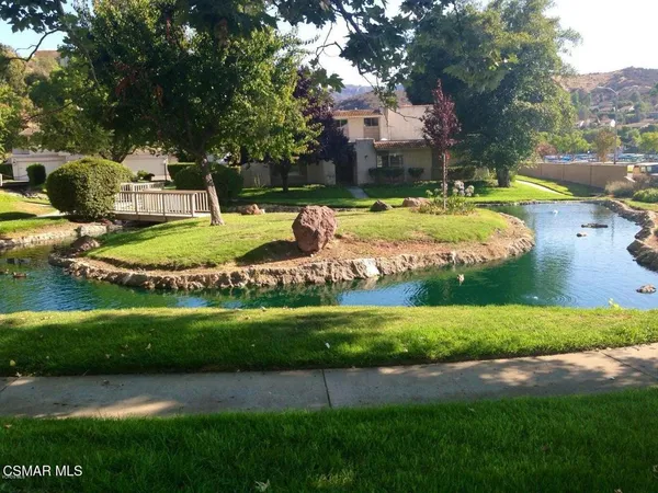 a view of a fountain in front of a house with a yard