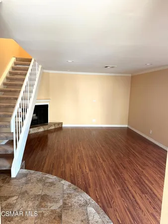 a view of a room with wooden floor and windows