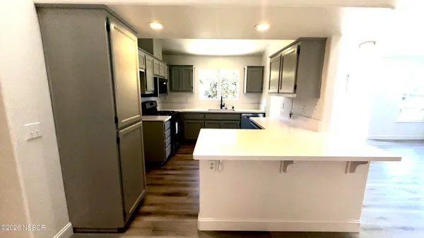 a kitchen with kitchen island a sink a counter top space and stainless steel appliances
