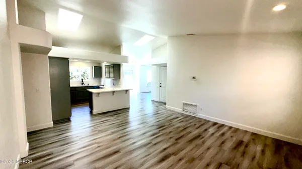 a view of a kitchen and an entryway with wooden floor