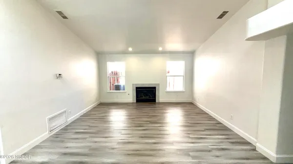 an empty room with wooden floor and fireplace