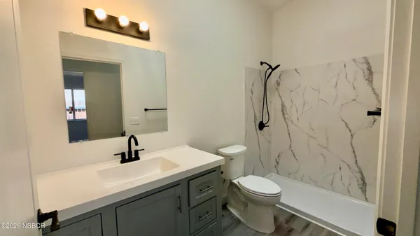 a bathroom with a sink a toilet and shower