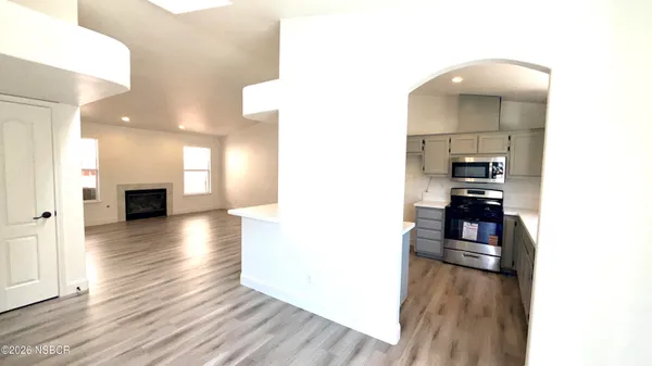 a view of a living room with kitchen and furniture