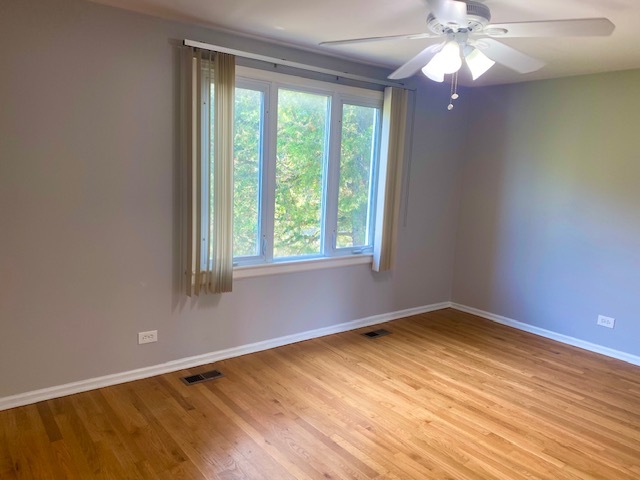 3420 Winnetka Road Glenview, IL 60026 - Photo 13 of 26 a view of an empty room with wooden floor and a window