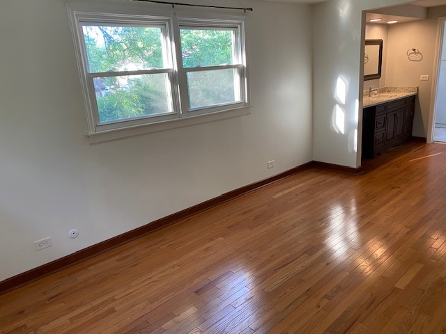 3420 Winnetka Road Glenview, IL 60026 - Photo 18 of 26 an empty room with wooden floor windows and cabinet