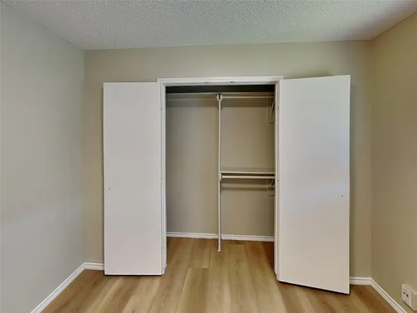 a view of walk in closet with wooden floor