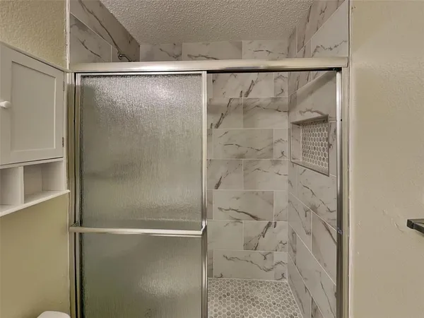 a bathroom with a glass shower door