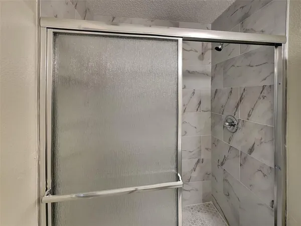 a bathroom with a glass shower door