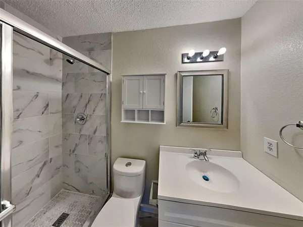 a bathroom with a sink a toilet and shower