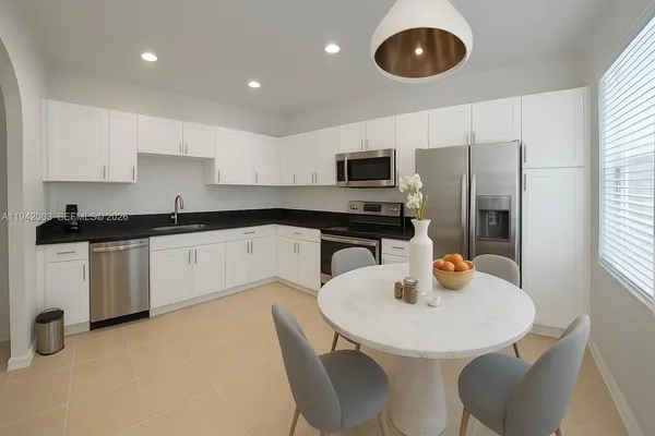a kitchen with stainless steel appliances granite countertop a sink a stove a microwave a refrigerator and cabinets