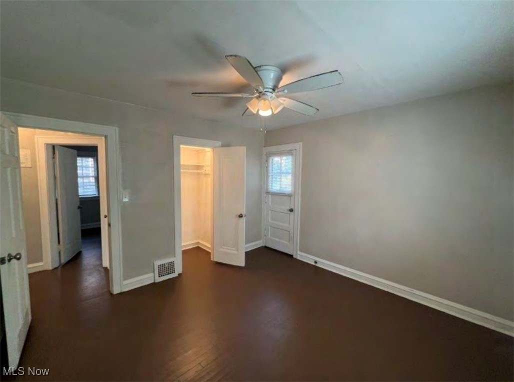 3579 Riedham Road Cleveland, OH 44120 - Photo 7 of 13 Unfurnished bedroom featuring dark wood-type flooring, a walk in closet, ceiling fan, and a closet