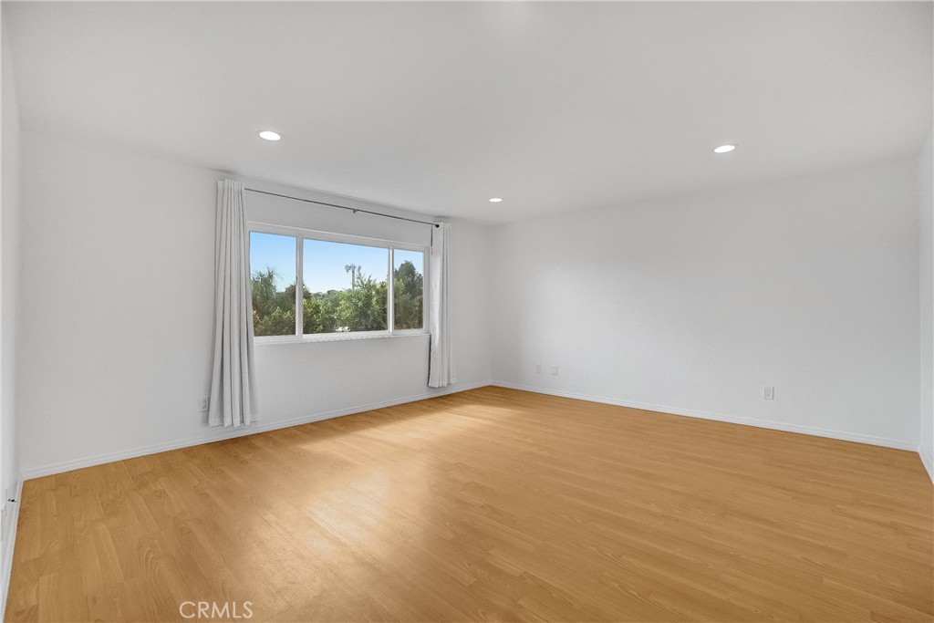 76 Millbrook Irvine, CA 92618 - Photo 26 of 51 a view of an empty room with wooden floor and a window