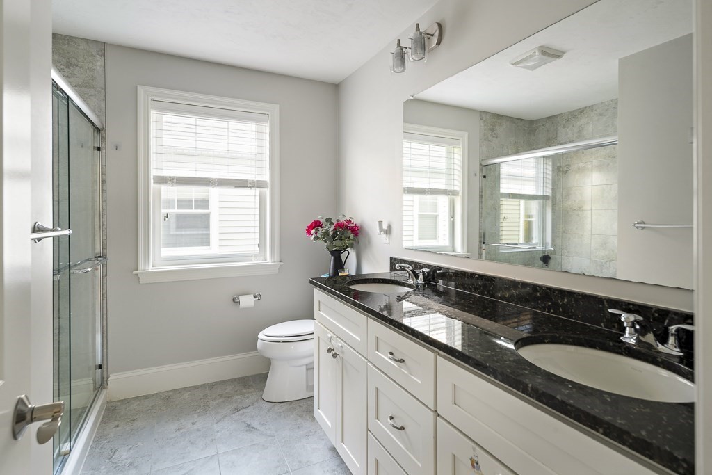 25 Oxbow Road, Unit 25 Framingham, MA 01701 - Photo 28 of 34 a bathroom with a granite countertop double vanity sink a mirror and a window