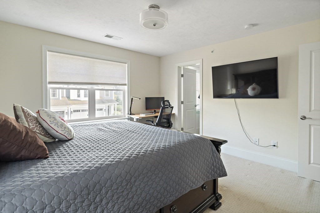 25 Oxbow Road, Unit 25 Framingham, MA 01701 - Photo 30 of 34 a bedroom with a bed a television and a large window