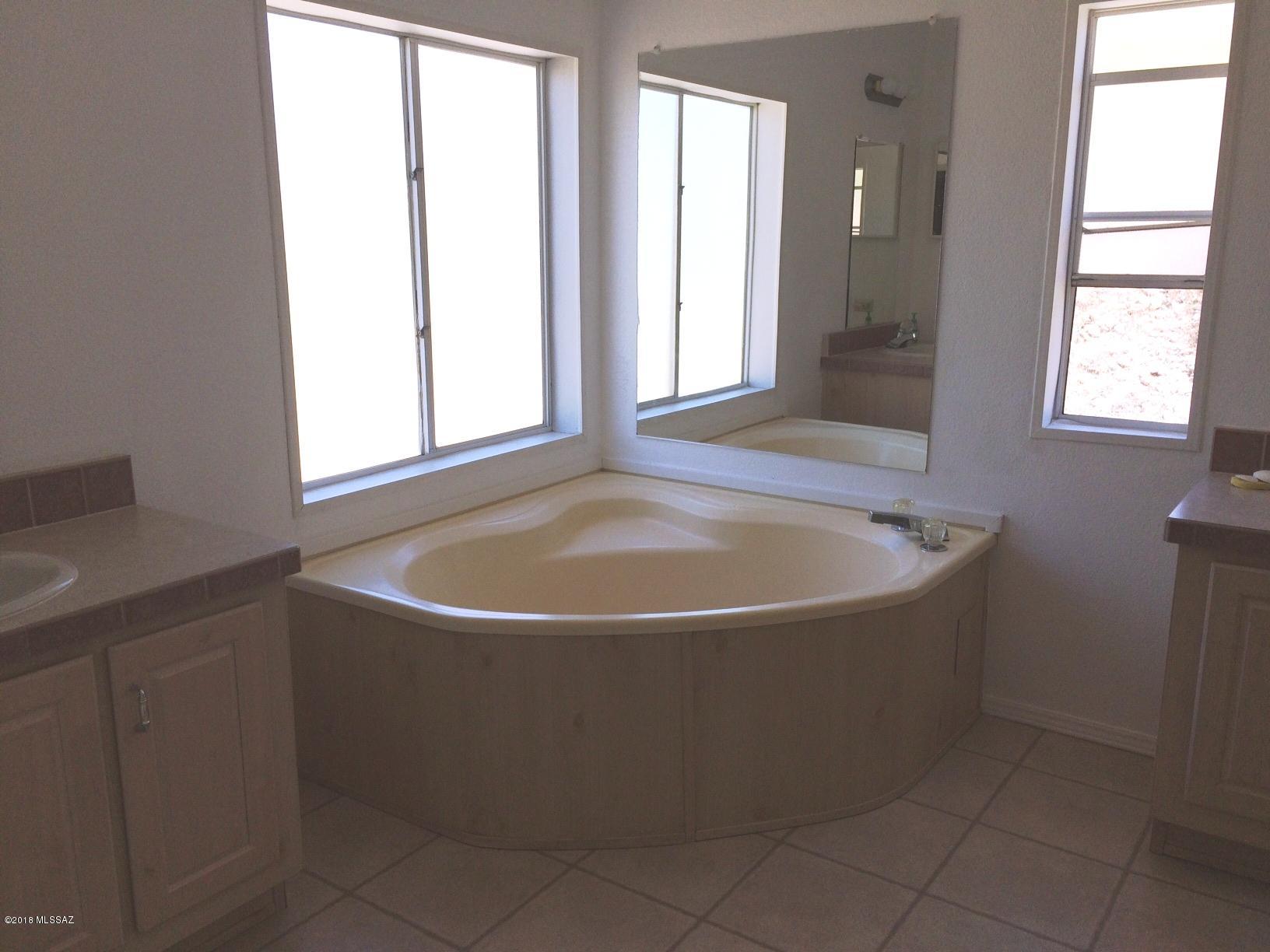 15146 North Ironwood Tree Road Tucson, AZ 85739 - Photo 7 of 9 a bath tub sitting in a bathroom next to a window