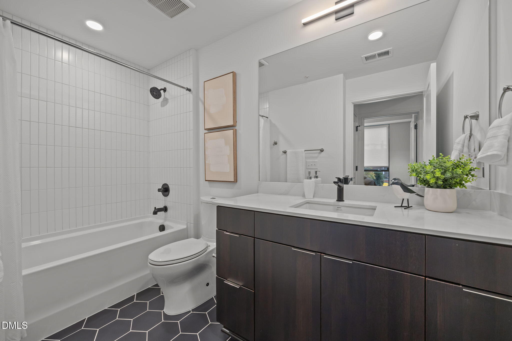 615 West Peace Street, Unit 202 Raleigh, NC 27603 - Photo 12 of 24 a bathroom with a sink a toilet and a large mirror