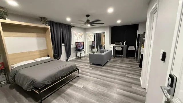 a bedroom with a bed couch and a large window