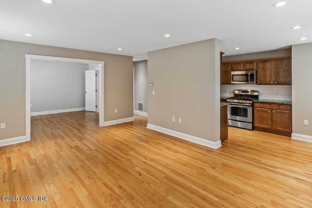 18 Charles Street, Unit B Greenwich, CT 06830 - Photo 4 of 14 an empty room with wooden floor and stainless steel appliances