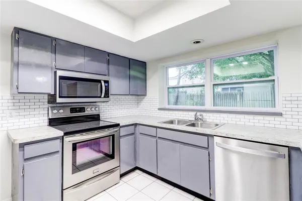 a kitchen with a sink stove and microwave