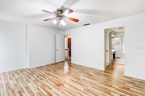 a view of a room with wooden floor and ceiling fan