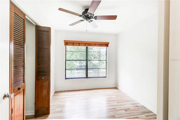 a view of an empty room with a window and a ceiling fan