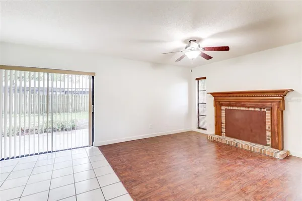 a view of an empty room with a fireplace and a window