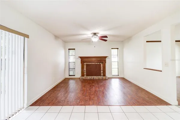 a view of an empty room with a fireplace and a window