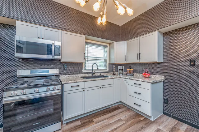 a kitchen with stainless steel appliances granite countertop a stove and a sink