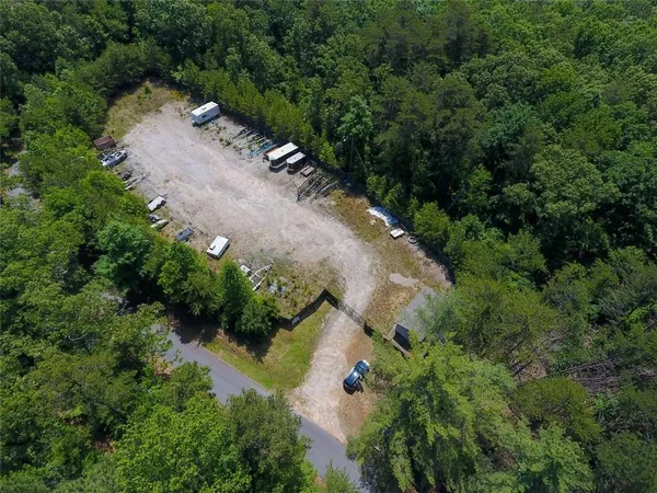 an aerial view of residential house with outdoor space and trees all around