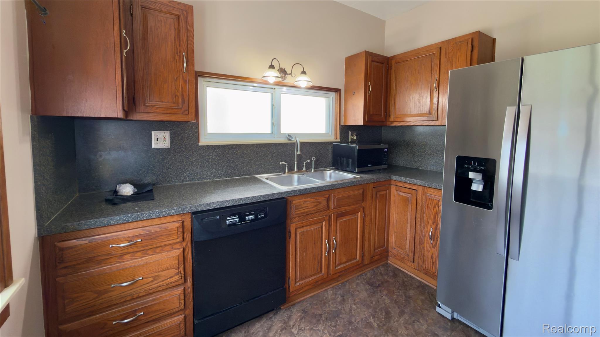 130 Elm Street River Rouge, MI 48218 - Photo 13 of 20 Kitchen featuring wood cabinetry, laminate countertops, a stainless steel refrigerator, a double basin sink, and a dishwasher