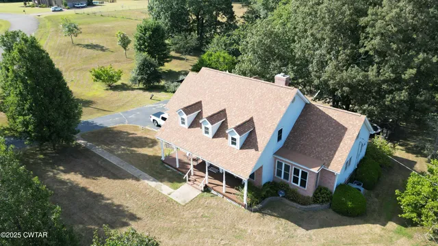 a front view of a house with a garden and trees