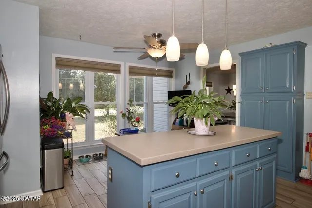 a kitchen with a table a chandelier and wooden floor