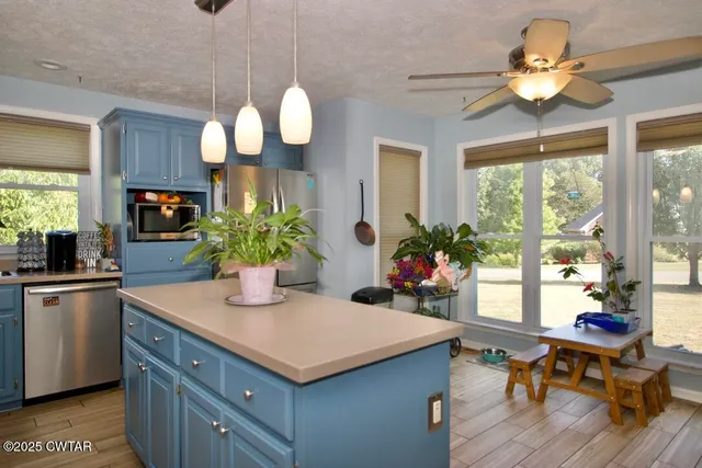 a kitchen with granite countertop a refrigerator a stove a sink and dishwasher