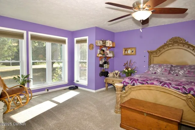 a bedroom with a bed and large windows