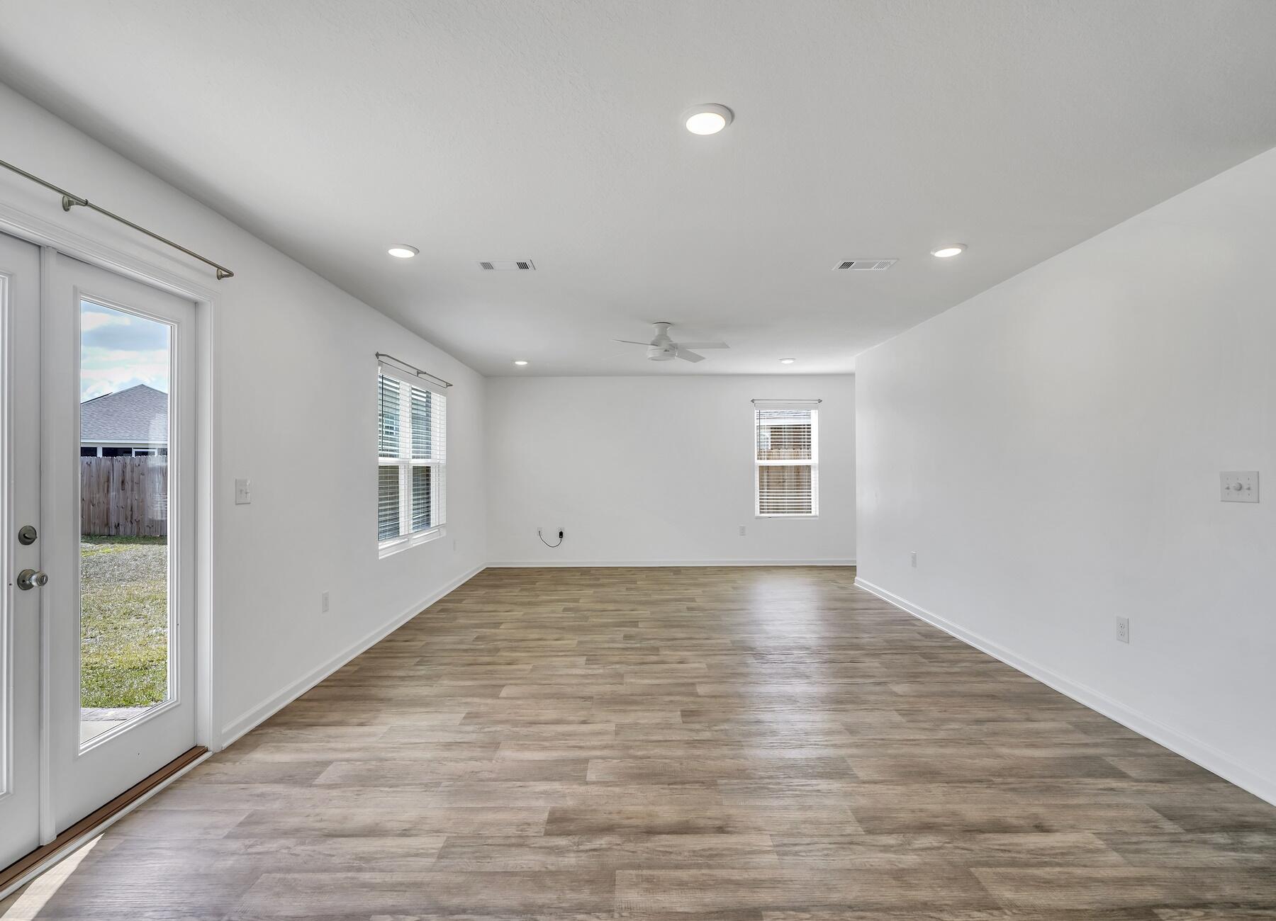 955 Merganser Way Crestview, FL 32539 - Photo 11 of 34 an empty room with wooden floor and windows