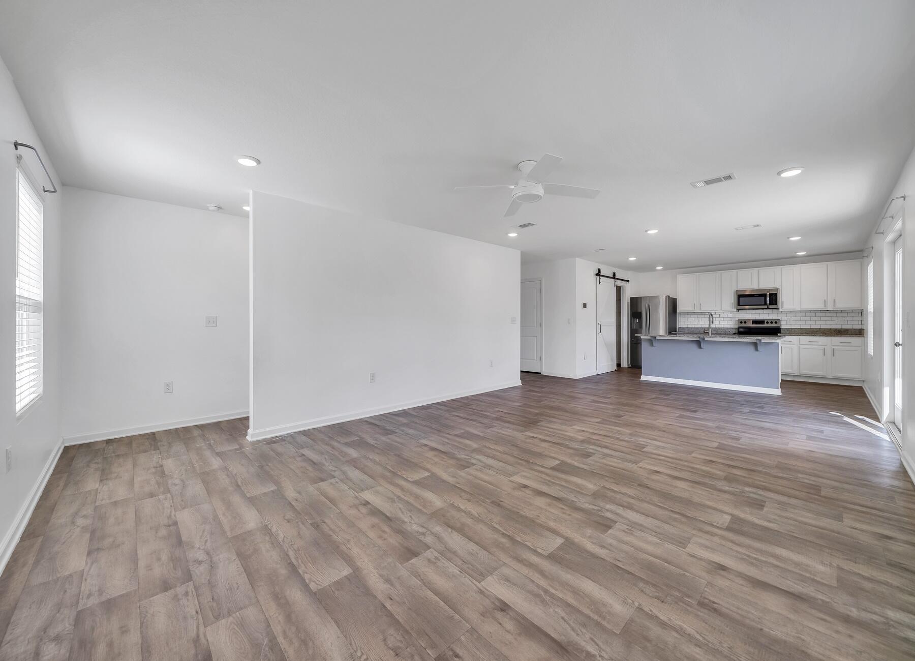 955 Merganser Way Crestview, FL 32539 - Photo 14 of 34 a view of a big room with wooden floor a kitchen and a window