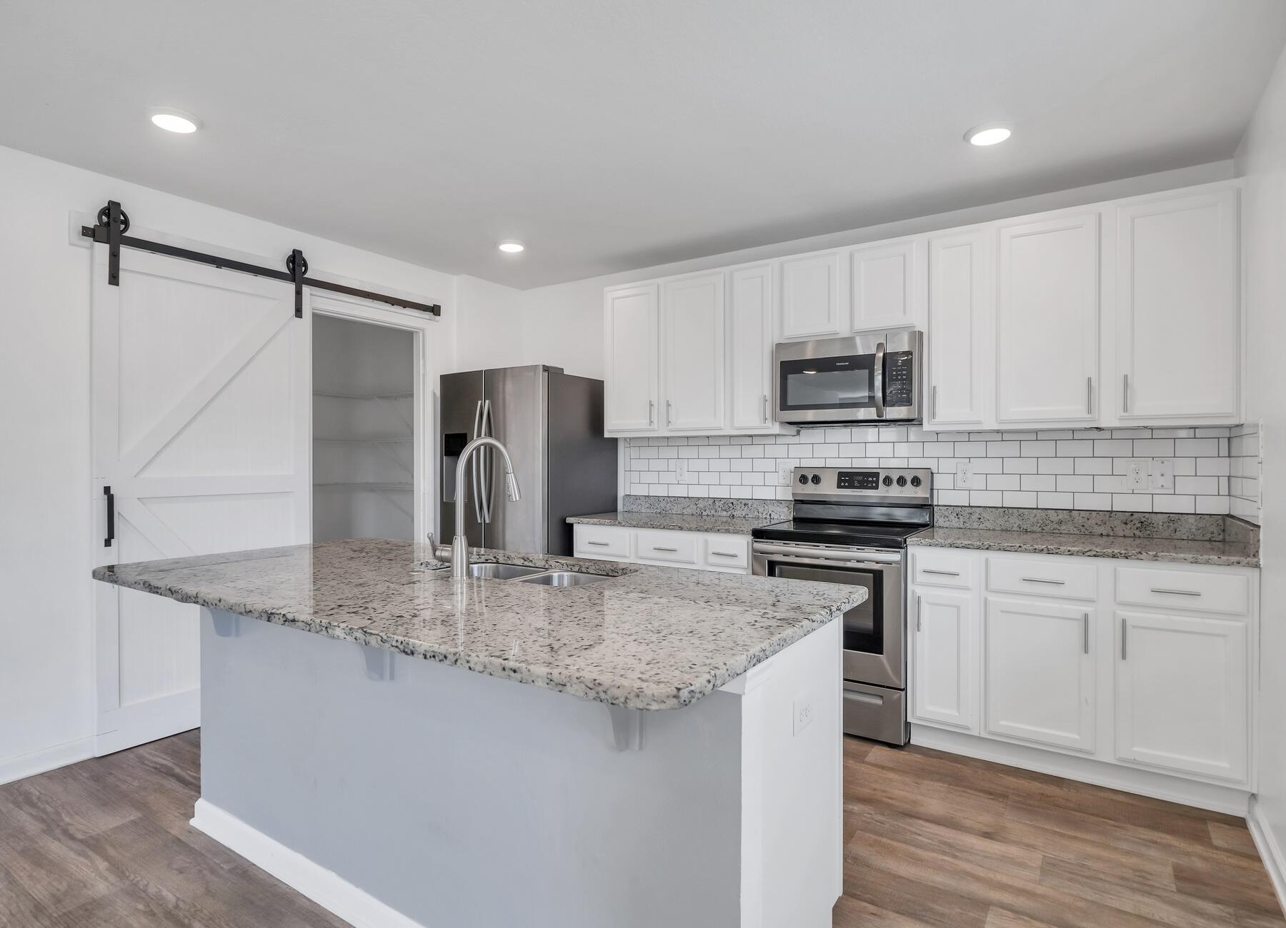 955 Merganser Way Crestview, FL 32539 - Photo 7 of 34 a kitchen with kitchen island granite countertop a stove sink microwave and refrigerator