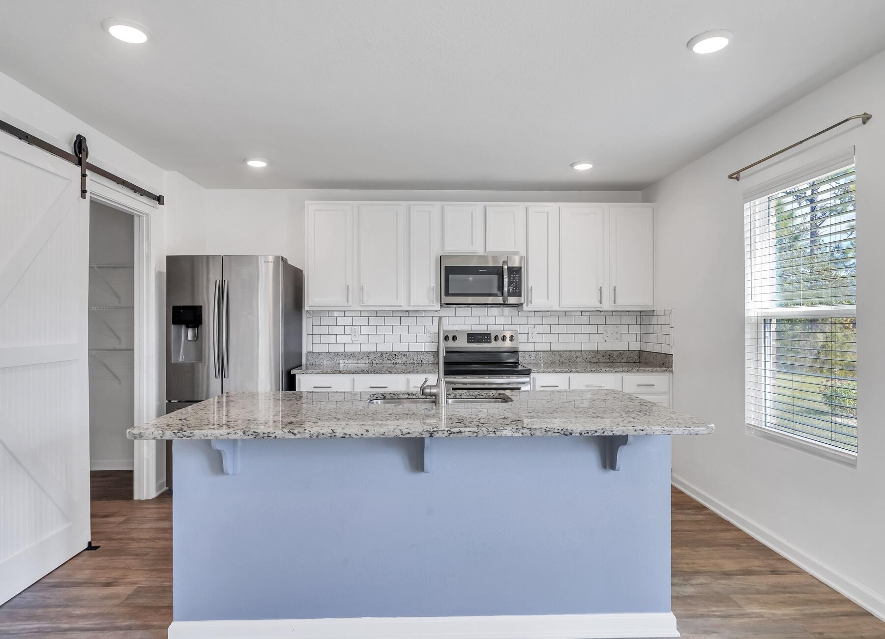 955 Merganser Way Crestview, FL 32539 - Photo 8 of 34 a kitchen with stainless steel appliances granite countertop a refrigerator a stove and a sink