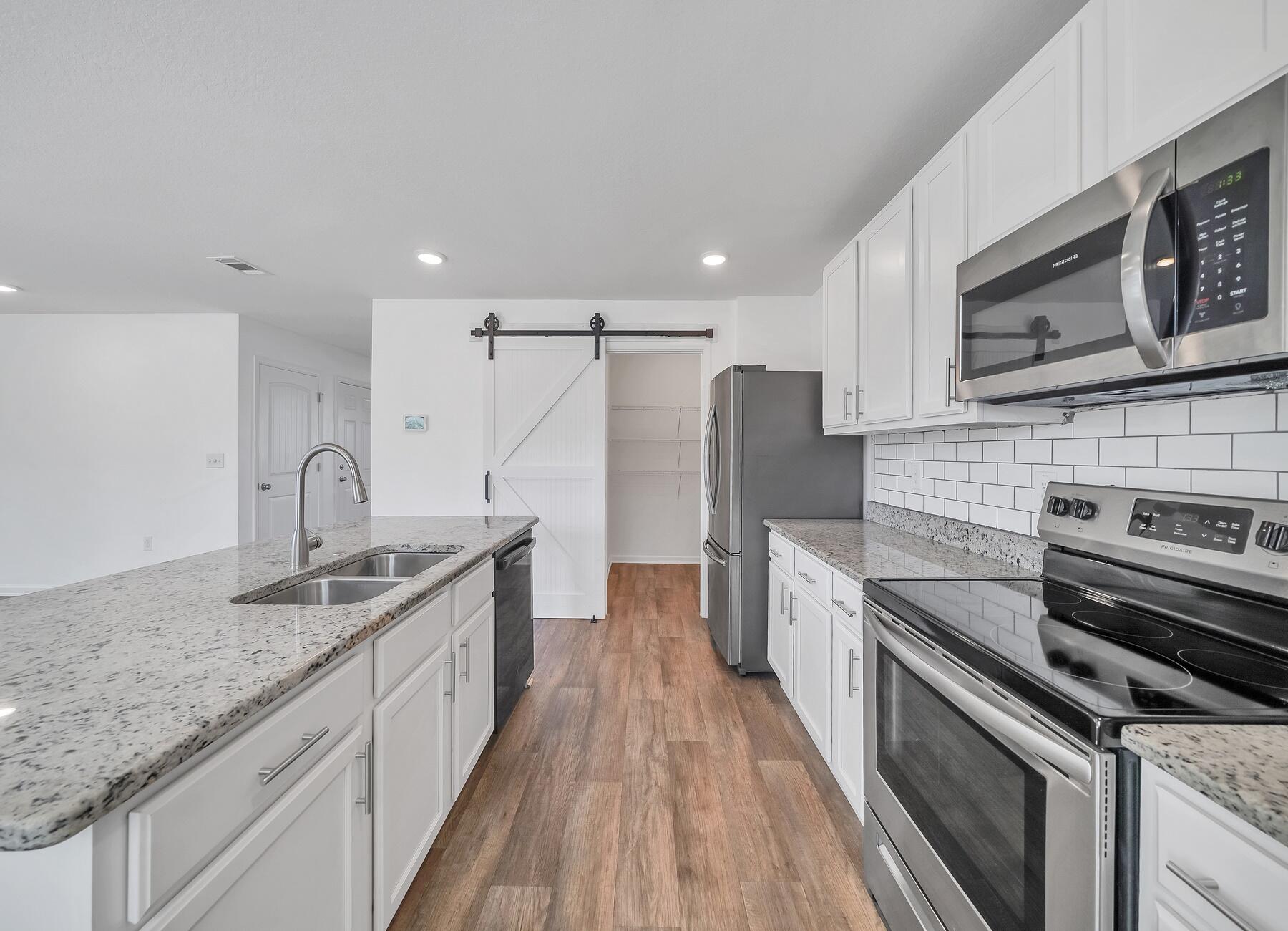 955 Merganser Way Crestview, FL 32539 - Photo 10 of 34 a kitchen with stainless steel appliances granite countertop a sink stove and refrigerator