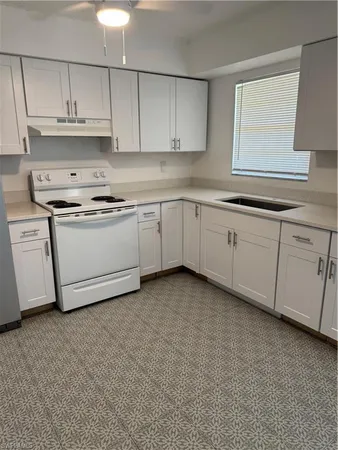 a kitchen with granite countertop white cabinets and white appliances