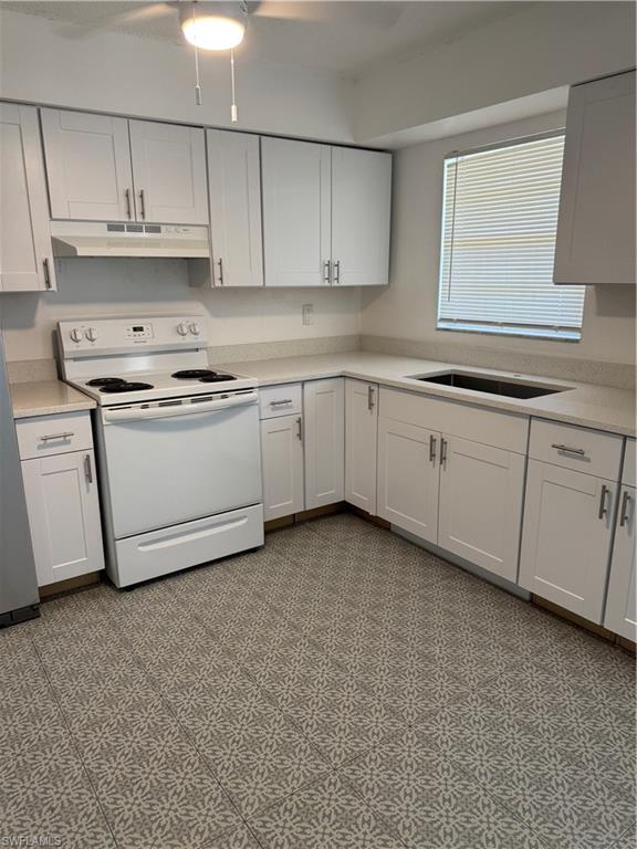 3325 Airport-Pulling Road North, Unit E4 Naples, FL 34105 - Photo 5 of 11 a kitchen with granite countertop white cabinets and white appliances