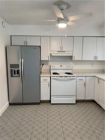 a kitchen with cabinets stainless steel appliances and a counter space
