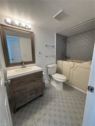 a bathroom with a toilet a sink and mirror