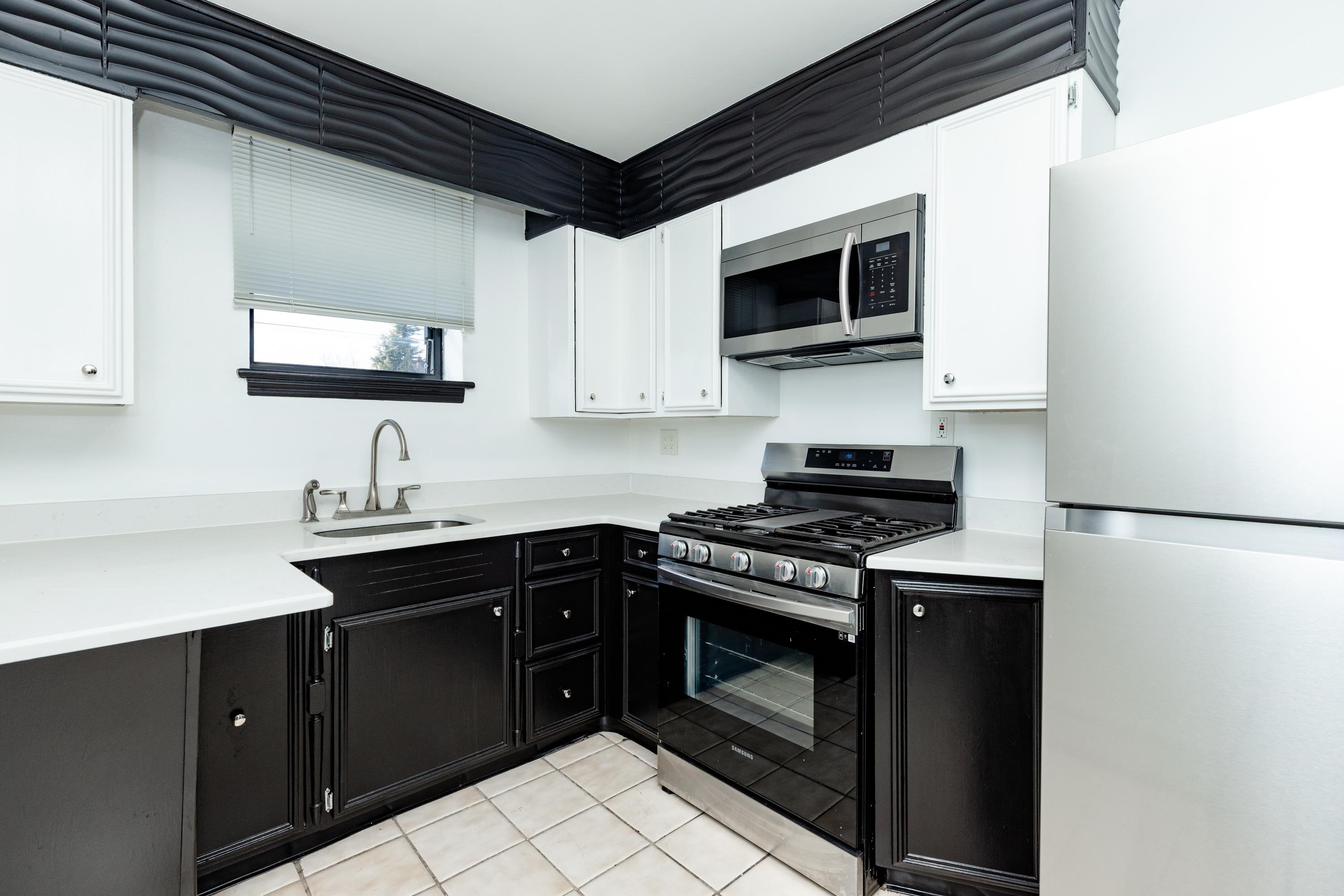 100 Lakeview Avenue, Unit 2A Clifton, NJ 07011 - Photo 12 of 13 a kitchen with stainless steel appliances a stove a sink and a microwave