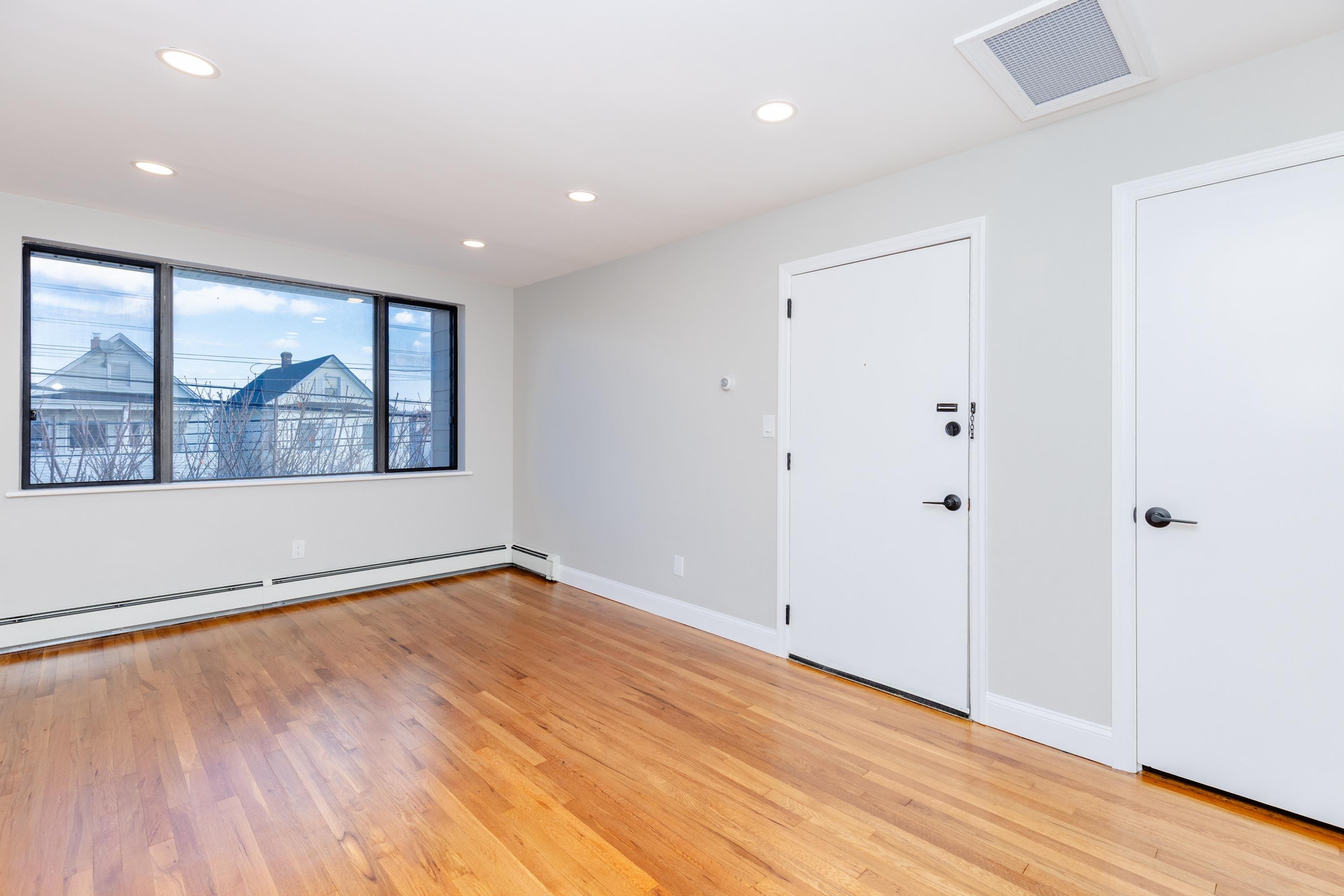 100 Lakeview Avenue, Unit 2A Clifton, NJ 07011 - Photo 5 of 13 wooden floor in an empty room with a window