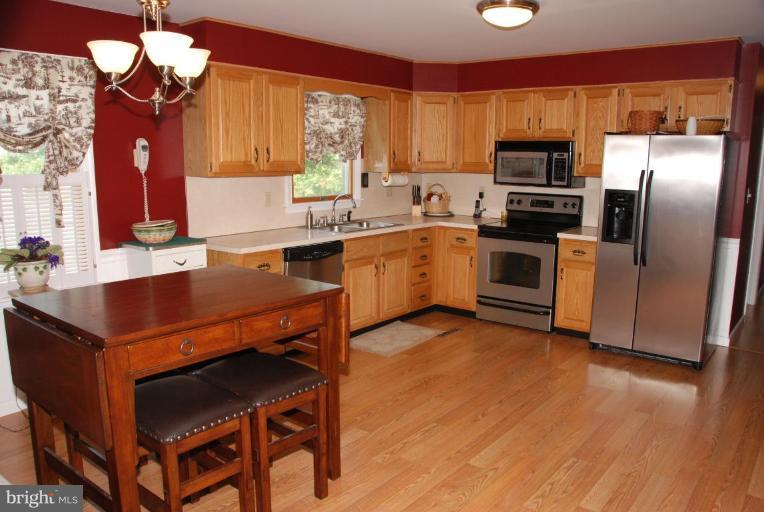 13046 Independence Road Clear Spring, MD 21722 - Photo 25 of 26 a kitchen with a refrigerator a stove a sink and dishwasher with wooden floor
